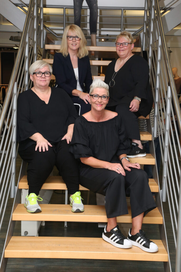 Die Vier vom Pittsbörg-Team mit Birgit Busse auf den Treppenstufen des Fashion-Store